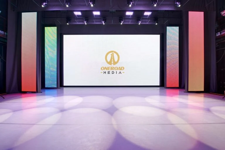 ONEROAD Media LED stage setup with central display and vertical LED panels