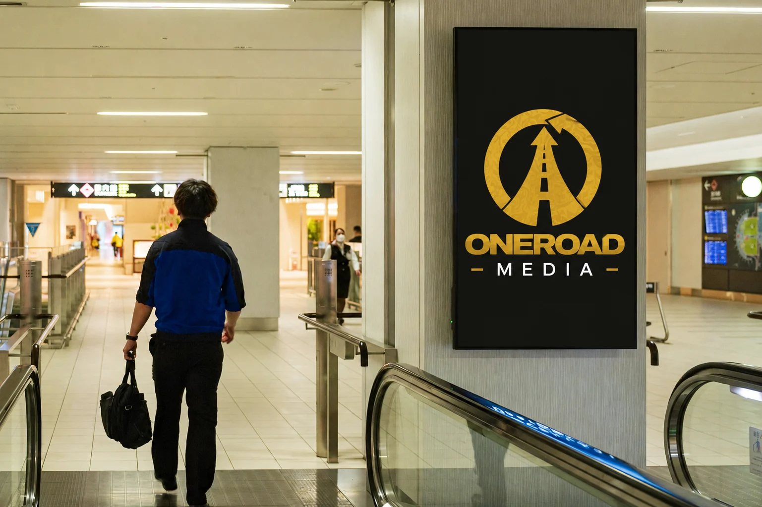 Man walking past ONEROAD Media digital signage in a modern building lobby